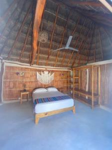 塞莱斯通Cabañas Cinco Elementos的一间位于稻草屋顶的卧室,配有一张床