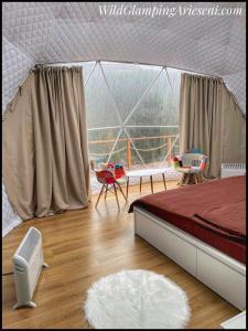 阿列谢尼WildGlampingArieseni的一间卧室配有带一张床和椅子的帐篷