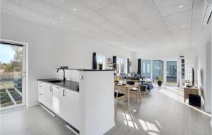 勒兹比Cozy Home In Rdby With House A Panoramic View的厨房以及带白色墙壁和桌子的用餐室