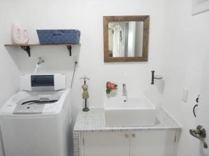 石垣岛Vacances a la mer Ishigaki的白色的浴室设有水槽和镜子