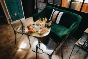 波尔多La Belle Endormie B&B French Guest house的一张桌子,上面有食物,还有绿色的沙发