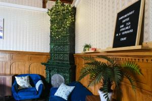 赫尔辛基戴安娜公园旅舍的客厅设有蓝色的沙发和绿色的柱子