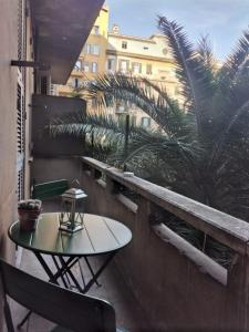 罗马普林奇比欧金尼奥酒店的棕榈树阳台的桌椅