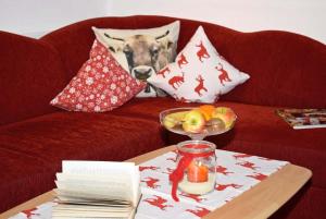 雷滕贝格Gsolhof的红色的沙发,上面有一张桌子和一碗水果