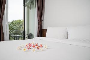 班奥南矛Circle Inn Ao Nam Mao的一张白色的床,上面有鲜花