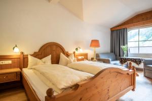 米特尔贝格拉岑霍夫自然酒店的一间卧室配有一张大型木床和椅子
