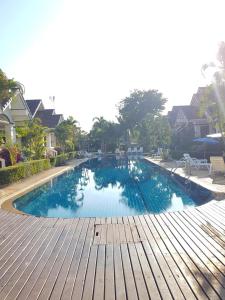 罗勇House in Ban Phe, Thailand的一座带木甲板的大型游泳池