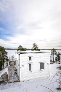 斯德哥尔摩New lakehouse - amazing sea view and private pier!的湖边雪地里的白色小房子