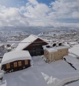迈季代勒舍姆斯ארואד סוויטס Arwad suites的一座被雪覆盖的建筑,以城市为背景