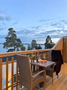 斯德哥尔摩New lakehouse - amazing sea view and private pier!的阳台上的木制甲板上配有桌椅