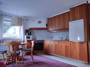 因斯布鲁克Ferienwohnung Elisa的厨房配有木制橱柜和桌椅