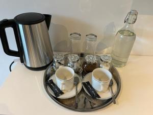 Saint-Georges-dʼAunayChez Thomas 7 Route du Monde Ancien的茶盘,桌子上放有杯子和玻璃杯,还有咖啡壶