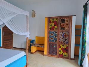 桑给巴尔Villa Adelina Zanzibar的一间卧室配有一张床和一个色彩缤纷的橱柜。
