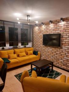 乔左维尔考普尔斯基FRIENDS House的客厅配有沙发和砖墙电视