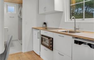 博托比2 Bedroom Beautiful Apartment In Vggerlse的白色的厨房配有水槽和微波炉
