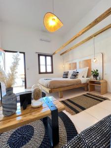 卡利诺岛Spongia Apartments Kalymnos的一间卧室配有一张床和一张木桌