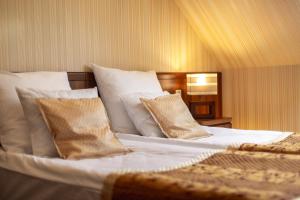 梅尔诺Dworek Morski SPA & Wellness的一间卧室配有带白色床单和枕头的床。
