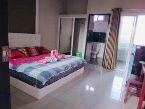 Ban Pa LanPreme Apartment @maejo的一间卧室配有一张带粉红色丝带的床