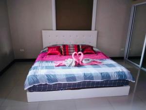 Ban Pa LanPreme Apartment @maejo的一间卧室配有带2个粉红色丝带的床