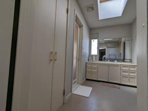 柳川柳川ゲストハウス 憩 (IKOI)的一间大厨房,配有白色的橱柜和水槽