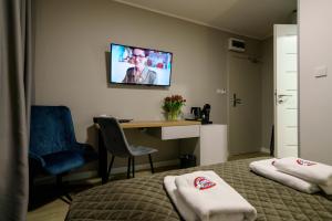 华沙Kamienica no 111a的酒店客房设有一张床、一张书桌和一台电视机。