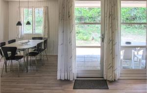 维斯特索马肯3 Bedroom Stunning Home In Aakirkeby的一间带桌椅和窗户的用餐室