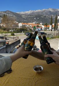 布德瓦Villa Merci Budva的一群人把啤酒瓶放在桌子上