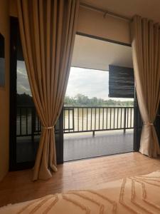 淡马鲁Chalet Terapung Laman Tok Ayah Temerloh的卧室设有大窗户,享有阳台的景色