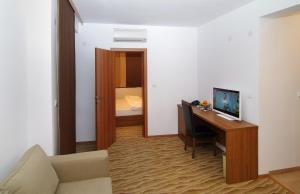 布尔加斯多罗酒店的客房设有一张桌子、一台电脑和一张沙发