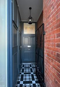 莱瑟姆-圣安妮The Apartments Lytham Square的一条带蓝色门和砖墙的走廊