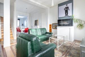 亚眠Maison Famille-Confort-Terrasse Jardin-Vue Cathédrale的客厅配有绿色真皮沙发和电视