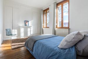 亚眠Maison Famille-Confort-Terrasse Jardin-Vue Cathédrale的一间卧室配有一张带蓝色床单和窗户的床。