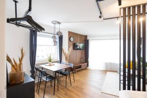 奥格斯堡NEW - Apartment - Augsburg - Universitätsklinikum的用餐室以及带桌椅的起居室。