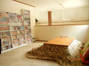 白马村Sakka Sanso山林小屋的一间设有桌子和书架的房间
