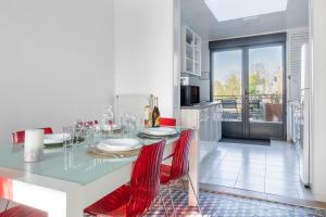 亚眠Maison Famille-Confort-Terrasse Jardin-Vue Cathédrale的一间带桌子和红色椅子的用餐室