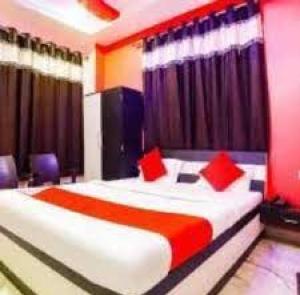 AraHotel Vinayak Vihar, Sasaram的一间卧室配有一张带红色枕头的大床