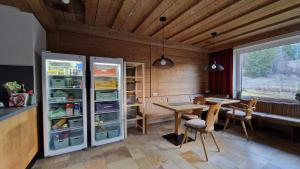 比伯维尔Alpinum Hostel的一间带冰箱和桌子的用餐室
