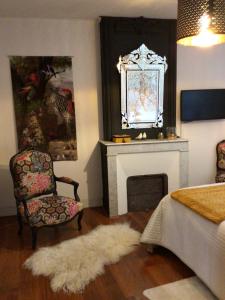 圣洛朗代古兹珍妮旅馆的客厅配有椅子和壁炉