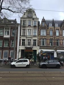 阿姆斯特丹Frank’s and Chong’s excellent location的两辆车停在大楼前