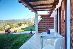 奥尔比亚Sardinia Green Park Country Lodge的享有美景的庭院配有桌椅。