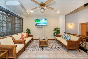 芭东海滩Solene Home Patong的客厅配有柳条家具和吊扇