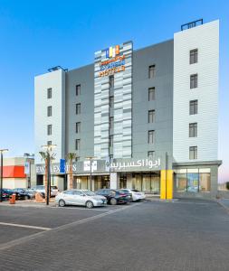 塞卡凯Ewaa Express Hotel - Al Jouf的停车场内有车辆的旅馆