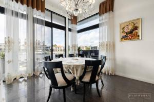黄金海岸stunning prestige residence的一间带桌椅和大窗户的用餐室
