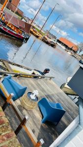 哈尔德韦克Woonboot 4 Harderwijk的码头上设有蓝色椅子的码头景