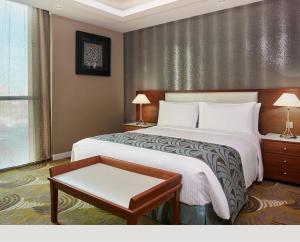 科威特科威特阿尔萨拉亚市假日酒店的酒店客房配有一张床铺和一张桌子。