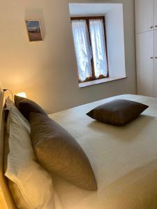 阿巴迪亚圣萨尔瓦托雷La Foglia的一张带两个枕头的床和窗户