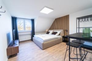 科布伦茨JAWO Apartments Koblenz modern & zentral, Küche & WIFI的一间卧室配有一张床、一张书桌和一台电视