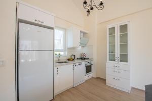 费特希耶SunTeos Villa Suites的厨房配有白色橱柜和冰箱。