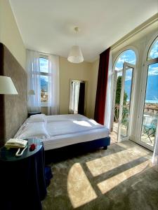 加尔达湖滨Villa Miravalle的一间卧室设有一张大床和一个大窗户