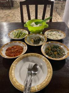 比拉Home Stay Ramli的桌上放有盘子和碗的食物